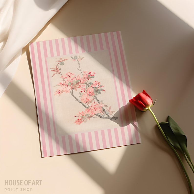 May include: A floral print art print with a pink striped border. The print features a branch of pink flowers. A red tulip with green leaves is next to the print. The text "HOUSE OF ART PRINT SHOP" is at the bottom.