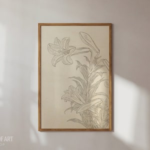 Op de afbeelding: Een ingelijste print van een zwart-witte lijntekening van een lelie. De lelie is getekend in een vintage stijl met delicate details. De achtergrond is licht beige.