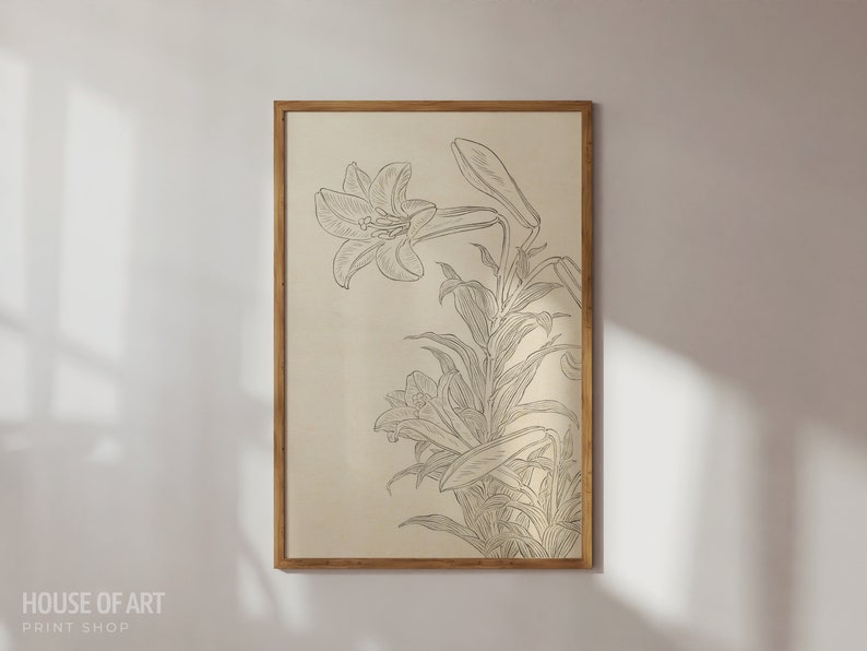 Op de afbeelding: Een ingelijste print van een zwart-witte lijntekening van een lelie. De lelie is getekend in een vintage stijl met delicate details. De achtergrond is licht beige.