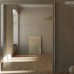 Op de afbeelding: Een lichtbruine kamer met een groot raam en een ingelijste print van een bloemenontwerp aan de muur. De kamer heeft een houten vloer en een deur die naar een andere kamer leidt.