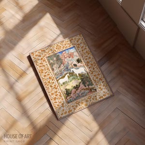 May include: An ornate framed print featuring a detailed illustration of two white horses in a landscape with trees and mountains. The frame has a gold floral pattern. The print is on a wooden floor.