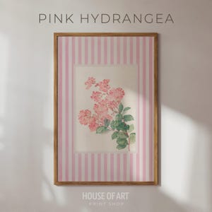 May include: A framed print featuring pink hydrangea blossoms and green leaves. The artwork is set against a background of vertical pink and white stripes. The text "PINK HYDRANGEA" and "HOUSE OF ART PRINT SHOP" are visible.