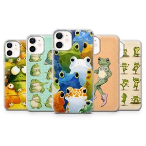May include: A collection of phone cases featuring colorful frog illustrations. The cases display various frog designs, including cartoon frogs in different poses and colors, such as green, blue, orange, and yellow. The cases are designed to fit a smartphone.
