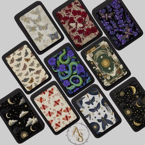 May include: A collection of rectangular trays with black borders, each featuring a unique design. The designs include butterflies, roses, lavender with moths, moths, a snake with flowers, a celestial tarot card, moons and stars, red moths, and moths with celestial elements.