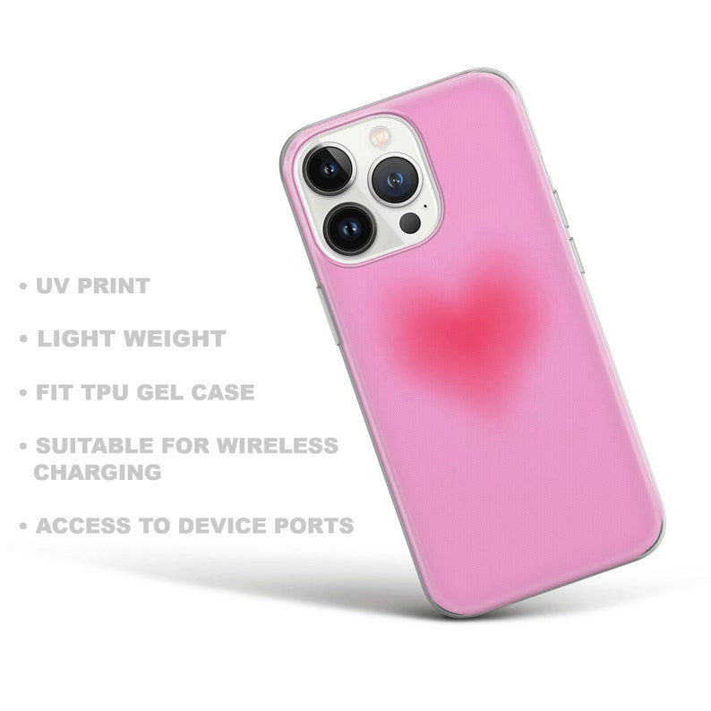 May include: A pink phone case with a red heart design. The case is made of TPU gel and is compatible with wireless charging.