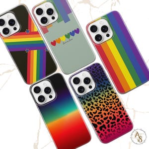 Puede incluir: Una colección de fundas para teléfonos con varios diseños. Una funda presenta un diseño de rayas arcoíris, otra tiene un estampado de leopardo y otras muestran corazones y rayas arcoíris. Las fundas son de varios colores.