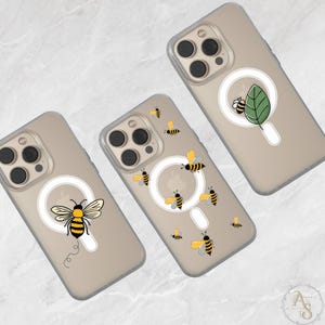 May include: Clear phone cases with bee designs. One case features a large bee, another has a bee and leaf, and the third has multiple bees. The bees are yellow and black, with a white circular design.