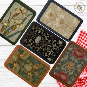 May include: A collection of decorative trays with floral designs. The trays feature various color schemes, including green, black, and tan, with detailed illustrations of irises, stylized flowers, and botanical patterns. Each tray has a contrasting border.