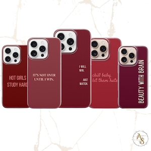 Può includere: Cinque custodie per telefoni bordeaux con testo bianco. Le custodie presentano frasi motivazionali come "I Will Win. Just Watch" e "Beauty With Brain". Le custodie sono progettate per smartphone e hanno una finitura lucida.