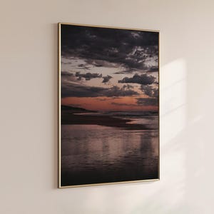 Póster "Atardecer rosa sobre el océano": Impresión artística de un cielo dramático y olas reflectantes, arte mural costero para interiores modernos y tranquilos.