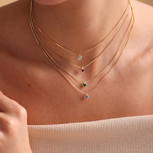 Puede incluir: Cuatro collares de cadena de oro con colgantes en forma de coraz&oacute;n. Los colgantes son de diferentes colores: transparente, rojo, verde y azul.