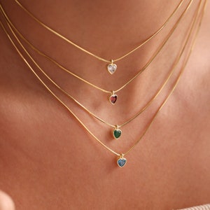 Puede incluir: Cuatro collares de cadena de oro con colgantes en forma de coraz&oacute;n. Los colgantes est&aacute;n adornados con piedras preciosas de diferentes colores: blanco, rojo, verde y azul.