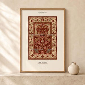 Puede incluir: Una impresión artística vertical enmarcada titulada Ruby Garden que presenta un patrón de alfombra floral detallado en rojo y crema con bordes intrincados. La impresión incluye el texto HEARTISTANBUL arriba y RUBY GARDEN abajo, en un marco de madera clara.