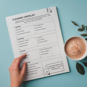Pu&ograve; includere: Un elenco di controllo delle pulizie su carta bianca con sfondo blu. L'elenco include attivit&agrave; per la camera da letto, il bagno, la cucina e la stanza. Una tazza di caff&egrave; e un rametto di foglie sono a destra.
