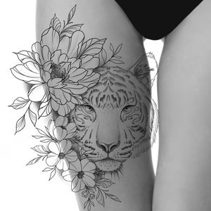 Puede incluir: Diseño de tatuaje en blanco y negro que presenta la cara de un tigre con elementos florales. La cara del tigre está sombreada, y las flores y hojas están intrincadamente dibujadas. El diseño está en un muslo.