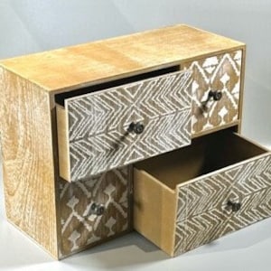 May include: A wooden storage box with three drawers. The drawers have a white and brown geometric pattern and metal knobs.