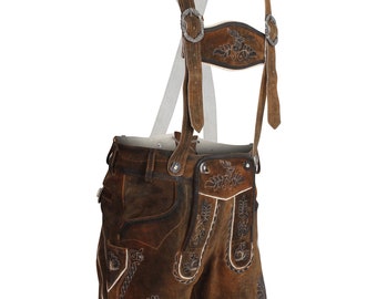 May include: Brown leather lederhosen featuring intricate light-colored embroidery on the front panels and leg cuffs. The garment includes adjustable suspenders with metal buckles and a matching chest bridge, showcasing detailed stitching and a rustic finish.
