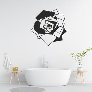 Peut inclure: Décor mural représentant une rose géométrique en noir et blanc. L'œuvre est accrochée sur un mur blanc au-dessus d'une baignoire blanche. Le design de la rose est composé de formes angulaires, créant une esthétique moderne et minimaliste.