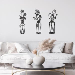 May include: A white ceramic mug with a black handle and the text "But First, Coffee" in a black, handwritten-style font. The mug is on a white surface.