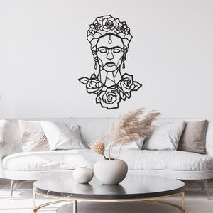 Peut inclure: Une décoration murale en métal noir représentant un dessin au trait géométrique du visage d'une femme orné d'une couronne de fleurs et de roses à la base. Le design utilise des lignes nettes et angulaires pour former le portrait.