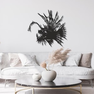 Peut inclure: Une décoration murale en métal noir en forme de baudroie avec un leurre proéminent, des dents acérées et des nageoires épineuses. La silhouette présente des découpes complexes et des structures squelettiques détaillées sur un mur blanc.