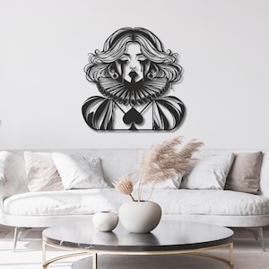 Op de afbeelding: Een zwart metalen wanddecoratie met een gestileerd portret van een persoon met golvend haar, dragend een grote geplooide kraag en een kledingstuk met een opvallend schoppensymbool op de borst, met donkere traanachtige markeringen onder de ogen.