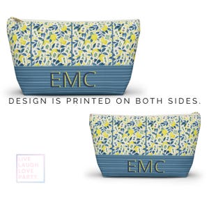 Op de afbeelding: Een make-up tasje met een citroen- en bladerenpatroon op een witte achtergrond. De tas heeft een blauw gestreepte onderkant met de gouden initialen "EMC". De tekst "DESIGN IS PRINTED ON BOTH SIDES" is ook zichtbaar.