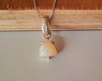 May include: A silver necklace featuring a triangular opal pendant with iridescent flashes of color. The metal bail is stamped with 925, indicating sterling silver. The pendant is suspended from a delicate silver chain with a polished finish.