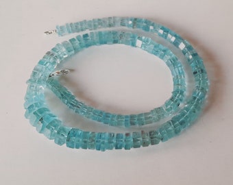 May include: A light blue aquamarine gemstone necklace with square-shaped beads. The necklace is made of natural stones and has a silver clasp.