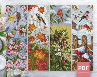 May include: Four cross stitch patterns featuring different seasons. The first pattern shows a bird in a blooming apple tree, the second shows a bird in a fall scene with red and yellow leaves, the third shows a bird in a summer scene with berries, and the fourth shows a bird in a winter scene with snow and a fence. The patterns are labeled "PDF Cross Stitch Pattern".