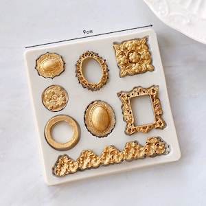 May include: A silicone mold with 9 different shapes, including frames, ovals, and circles. The mold is 9 cm wide and features a gold-colored design.