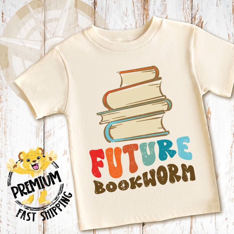Pu&ograve; includere: Una maglietta color crema con una pila di libri e il testo "FUTURE BOOKWORM" in lettere retr&ograve; colorate.