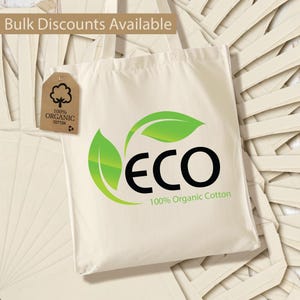 May include: A white tote bag with a green leaf logo that says "ECO 100% Organic Cotton". The bag has a brown tag that says "100% Organic Cotton".