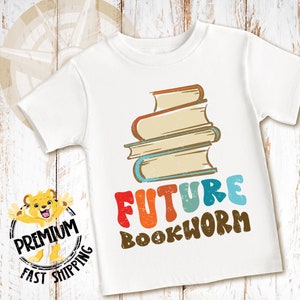 Pu&ograve; includere: Maglietta bianca con una pila di libri colorati e il testo "FUTURE BOOKWORM" in un font retr&ograve;.