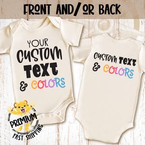 May include: A white baby bodysuit with short sleeves. The front of the bodysuit has the text "YOUR CUSTOM Text & COLORS" in black and rainbow colors. The back of the bodysuit has the text "CUSTOM Text & COLORS" in black and rainbow colors.