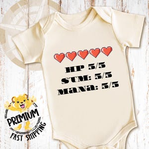 May include: A cream-colored baby onesie with a pixelated heart graphic and the text "HP 5/5 STM: 5/5 Mana: 5/5".