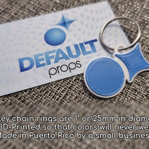 Puede incluir: Un llavero de 3D impreso en azul y blanco con un anillo. El llavero presenta un c&iacute;rculo con una superficie texturizada y un amuleto en forma de estrella. El llavero est&aacute; hecho en Puerto Rico por una peque&ntilde;a empresa. El texto "DEFAULT props" es visible en una tarjeta blanca detr&aacute;s del llavero.