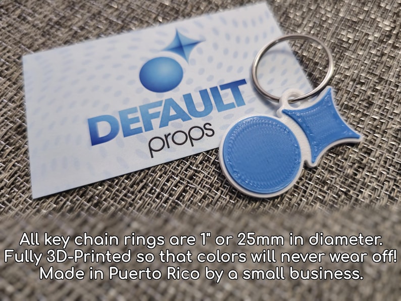 May include: A blue and white 3D printed keychain with a ring. The keychain features a circle and a star shape. The text "DEFAULT props" is visible on a white card behind the keychain.