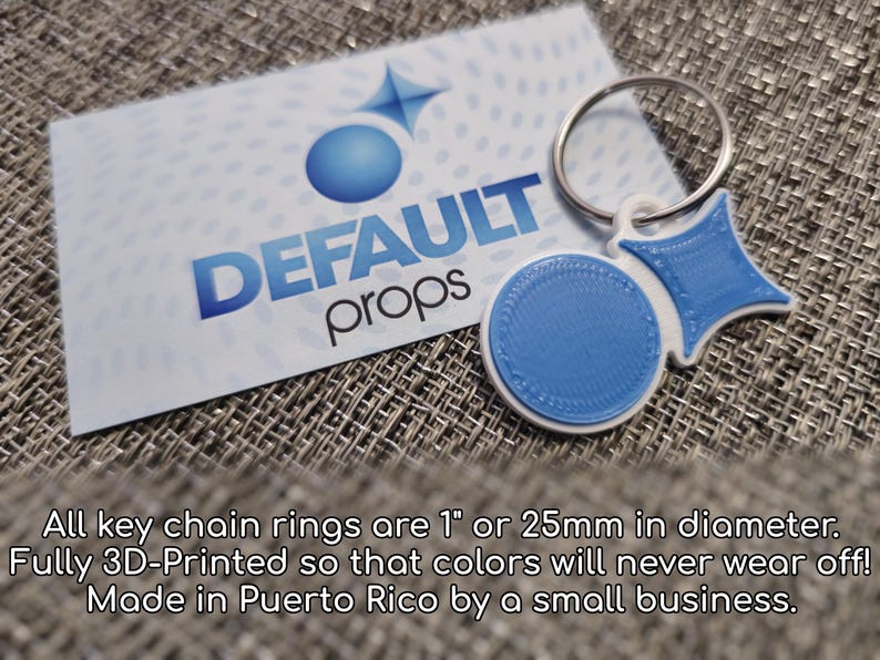 May include: A blue and white 3D printed keyring with a ring. The keyring features a circle and a star shape. The text "DEFAULT props" is on a white card behind the keyring.