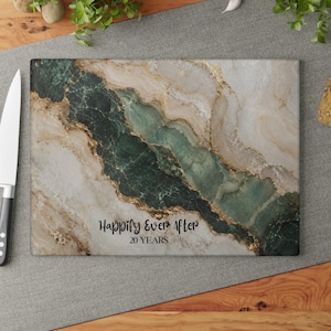 May include: Rectangular cutting board with a marble design in shades of green, white, and gold. The text "Happily Ever After 20 Years" is printed on the board. A knife is visible on the left side.