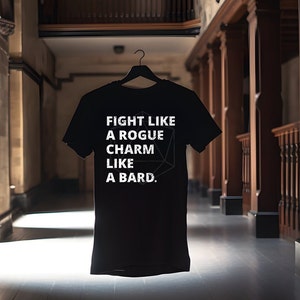 May include: Black t-shirt with white text that reads "Fight like a rogue, charm like a bard." A white geometric shape is behind the text.