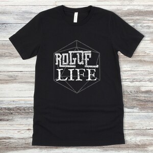 May include: Black t-shirt with a white graphic of a dice with the text "Rogue Life" inside.