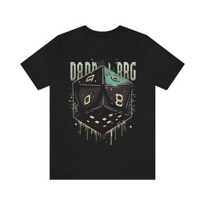 Op de afbeelding: Zwart T-shirt met een afbeelding van een grote, veelzijdige dobbelsteen met de tekst "D&D RPG" erboven.
