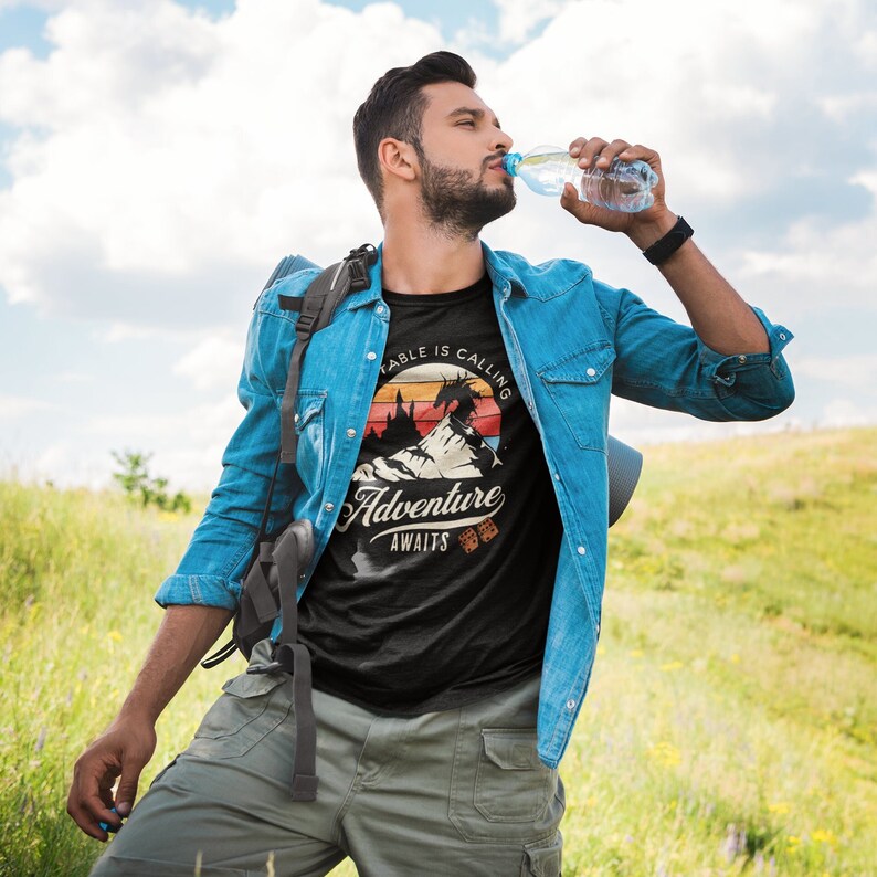 The table is calling adventure awaits dnd t-shirt design on a cool man with a beard in the mountains