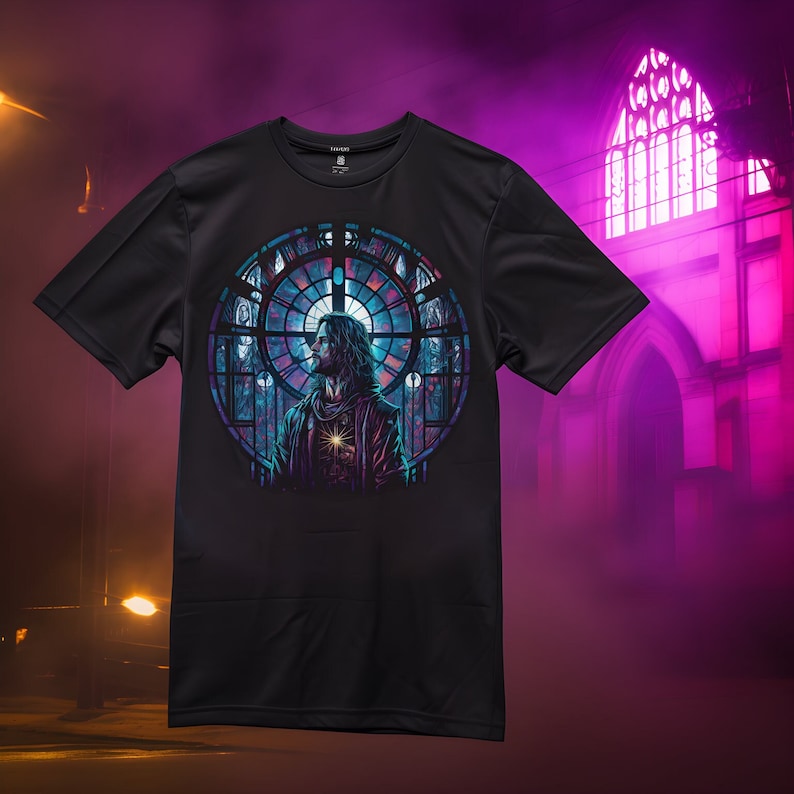 May include: Black t-shirt with a colorful stained glass window design featuring a person with long hair and a glowing heart. The design is set against a dark background.