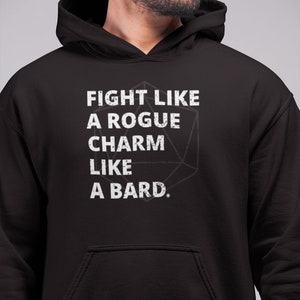 May include: Black hooded sweatshirt with a white graphic print that reads "Fight like a rogue, charm like a bard." The graphic also includes a stylised image of a 20-sided die.
