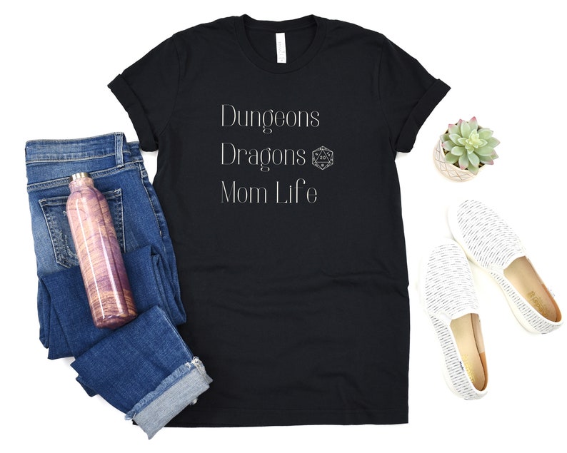 May include: Black t-shirt with white text that reads "Dungeons Dragons Mom Life" and a white Dungeons and Dragons dice symbol.