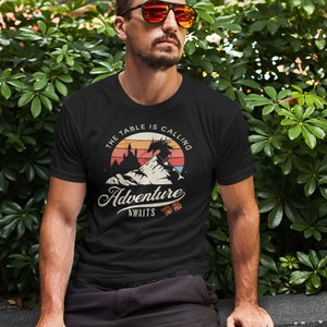 The table is calling adventure awaits dnd t-shirt design on a cool man with sunglasses in front of a bush