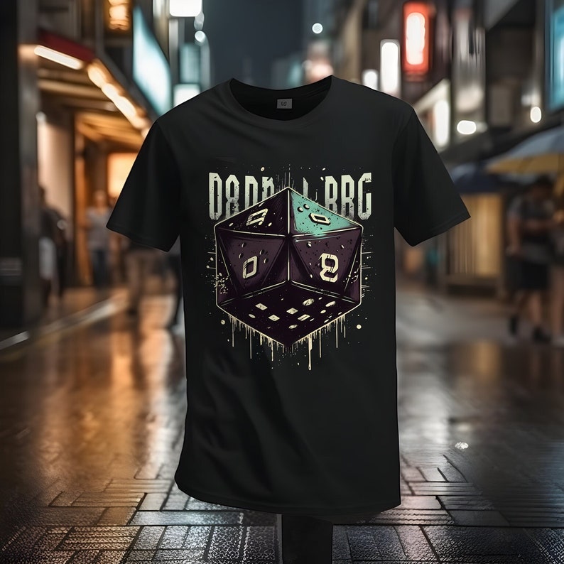 Op de afbeelding: Zwart T-shirt met een afbeelding van een zwarte en groene 20-zijdige dobbelsteen met de tekst "D&D RPG" erboven.