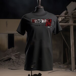 K&ouml;nnte beinhalten: Schwarzes T-Shirt mit einem abgenutzten roten und wei&szlig;en Grafik, auf dem "Dust World RPG Powered by the Apocalypse" steht.